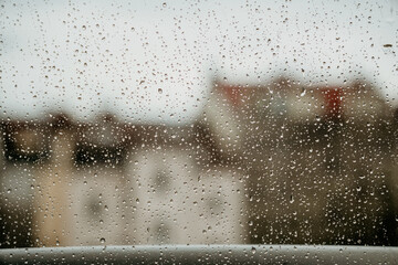 Rainy window with blurred view of Prague city in background