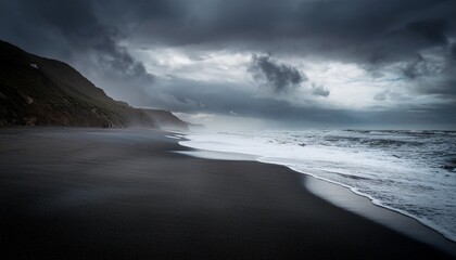 Obraz premium dark sand beach dramatic cloudy sky moody tones shore coast atmosphere
