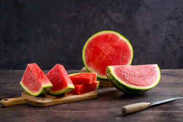Slices of fresh watermelon on the rustic wooden table, dark background