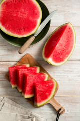 Slices of fresh watermelon on bright rustic wooden table.