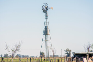 Scenic Windmill in a Lush Green Field Under Blue Sky