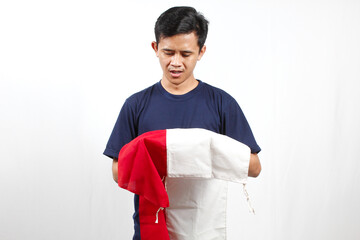 Asian man holding Indonesian flag with a sad look