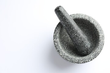 Stone mortar and pestle on white background, top view. Space for text