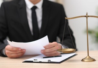 Judge working and scales on desk indoors, selective focus
