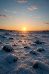 Naklejka premium Peaceful winter sunrise over a snow-covered rocky field with golden light casting long shadows, serene atmosphere ideal for seasonal landscapes and natural backgrounds
