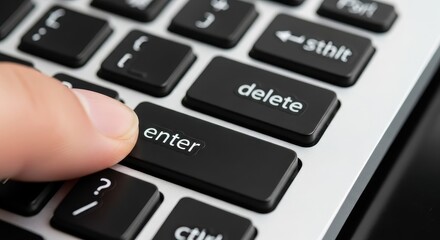 Close-up of finger pressing the Enter key on a laptop keyboard