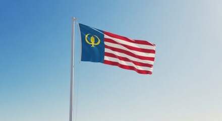 Fototapeta premium A national flag waves proudly against a clear blue sky