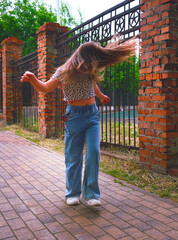 Happy young girl enjoying walking, dancing, jumping. Freestyle. Freedom and carefree....