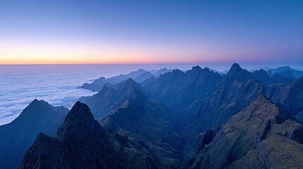 Obraz premium Majestic mountain range above a sea of clouds at dawn.