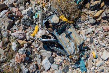 Overturned vehicle among rocky debris, emphasizing environmental impact and industrial waste. captivating view highlights destruction's stark contrast with rugged terrain.