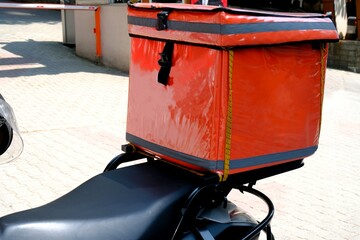 A courier delivers a food package order. Fast package service. Delivery man box and helmet...