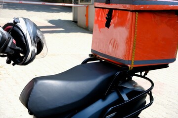 A courier delivers a food package order. Fast package service. Delivery man box and helmet...