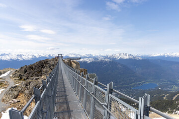 Suspension Bridge Over Mountainous Landscape in Whistler, BC, Under Clear Blue Skies