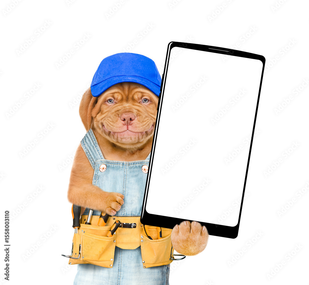 Poster smiling mastiff puppy wearing blue cap and overalls with tool belt showing big smartphone with white