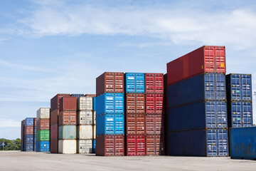 Colorful stacked shipping containers are neatly arranged under a clear blue sky at a freight yard. The image highlights global trade, logistics, and industrial transportation infrastructure.