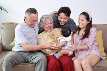 Asian family, grandpa, grandma, mom, dad, they smile happily welcome the new little baby boy, the family member. Baby care from birth to 1 year. Family concept.