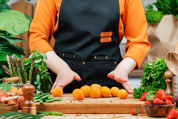 skilled chef sorts fresh fruits and vegetables on a wooden cutting board in a well-equipped kitchen, promoting healthy vegan recipes.