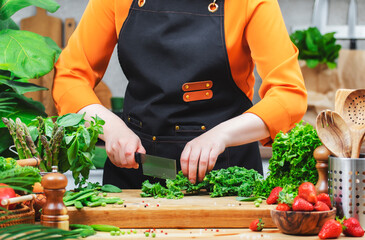 chef skillfully chops fresh kale greens and vegetables, showcasing healthy vegan cooking in a vibrant kitchen setting.