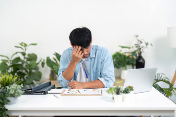 Remote Work and Stress Management. A man showing signs of stress while working from home,...