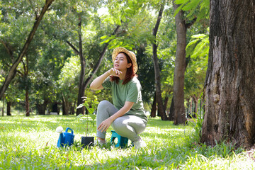Asian young woman volunteer wearing green shirt. She is planting trees to conserve forest. World Environment Day.