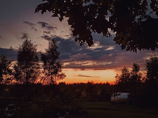 A Serene and Beautiful Sunset Over a Tranquil Landscape Enhanced by Silhouetted Trees