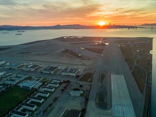 Aerial view of Alameda Naval Air Station runway at sunrise, with San Francisco skyline and Bay...