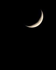 Crescent moon in night sky.
