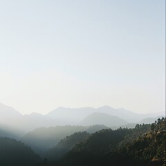 Obraz premium Layered mountain range landscape with morning mist