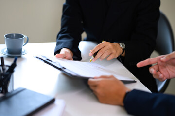Close up of business professionals discussing contract details at the office table
