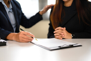 Business agent presenting a contract to client for review and approval at office desk