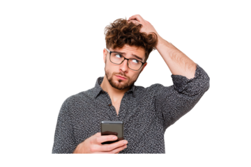 Pensive Young Man with Curly Hair, Wearing Glasses and a Black and White Dotted Shirt, Holding a Smartphone and Scratching His Head isolated on transparent background