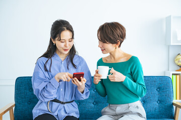 モダンなリビングでスマホを見る二人の女性