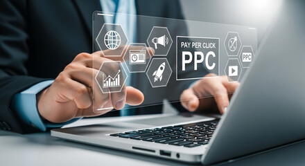 Man using laptop with pay per click interface and business icons overlaying the screen display area