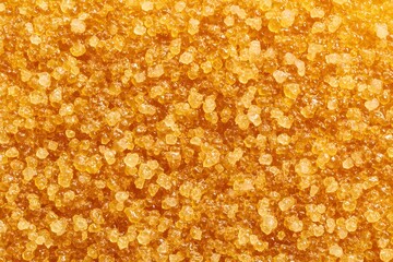 A close-up macro shot of coarse brown sugar, perfect for culinary, food, or texture-related projects. The granular details and golden color evoke warmth and deliciousness.