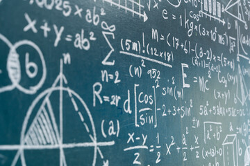 Close-up chalkboard with advanced math formulas, graphs, and scientific equations for education and learning concept
