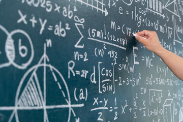 Hand writing complex mathematical formulas on chalkboard, concept of education, science, learning and logic
