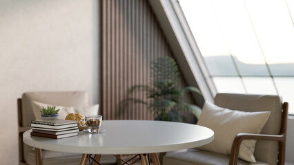 A glass cup of coffee with breads and book on white round table with armchair in living room or cafe
