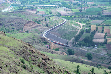 Passenger train hauled by a WAP7 electric locomotive near Pune India.