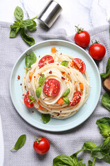 Plate with tasty pasta primavera on white marble background