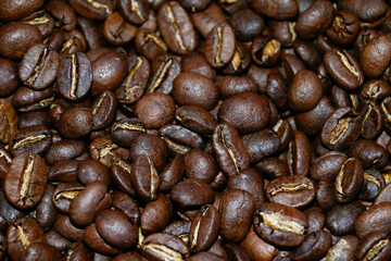 Top view background of aromatic brown coffee beans scattered on the surface.