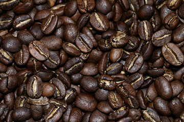 Top view background of aromatic brown coffee beans scattered on the surface.