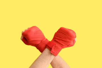 Female hands in boxing bandages on yellow background