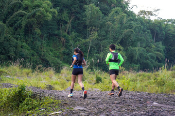 Asian Couple Trail Running in Forest, Rear View