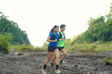 Asian Indonesian couple trail running outdoors, active sustainable lifestyle exercise