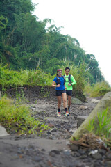 Asian Indonesian couple trail running outdoors, active sustainable lifestyle exercise
