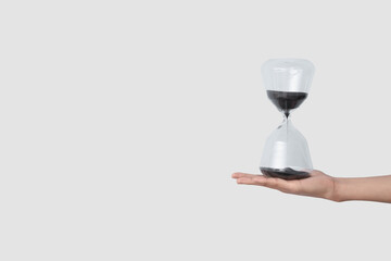 Female hand holding hourglass on blue background