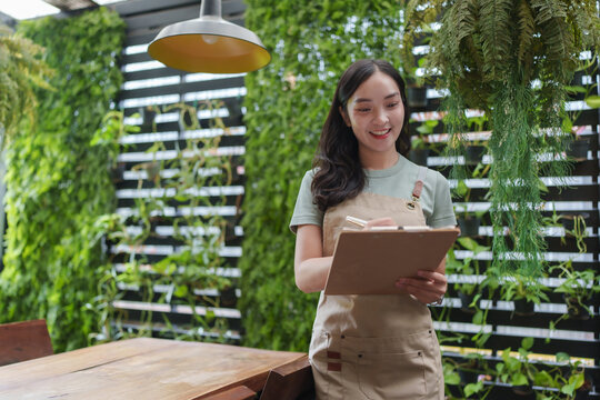 Smiling waitress taking orders in a green restaurant