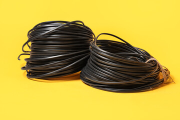 Rolled cables on yellow background, closeup
