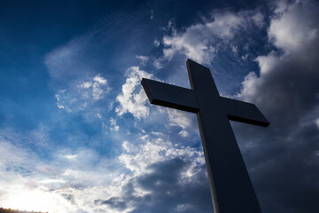 Metallic cross against a dramatic sky, symbolizing faith, hope and spirituality. Perfect for...