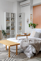 Interior of light bedroom with wind chime, dream catcher and shelf units